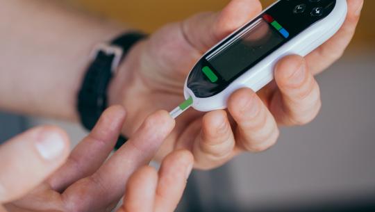 Person using finger stick to monitor diabetes