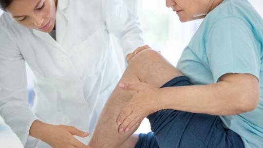 doctor looking at woman's leg