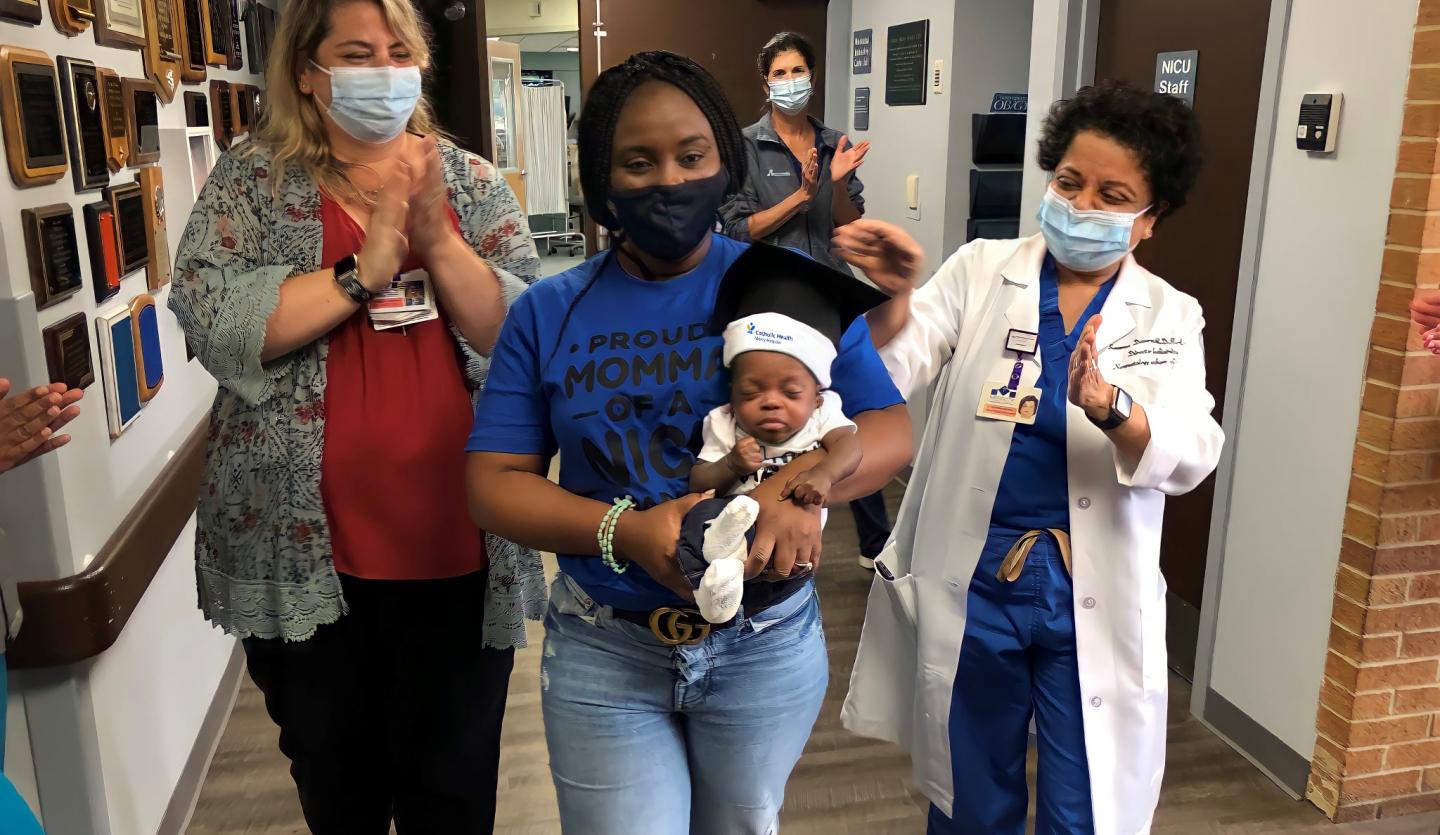 baby zion with mom and staff