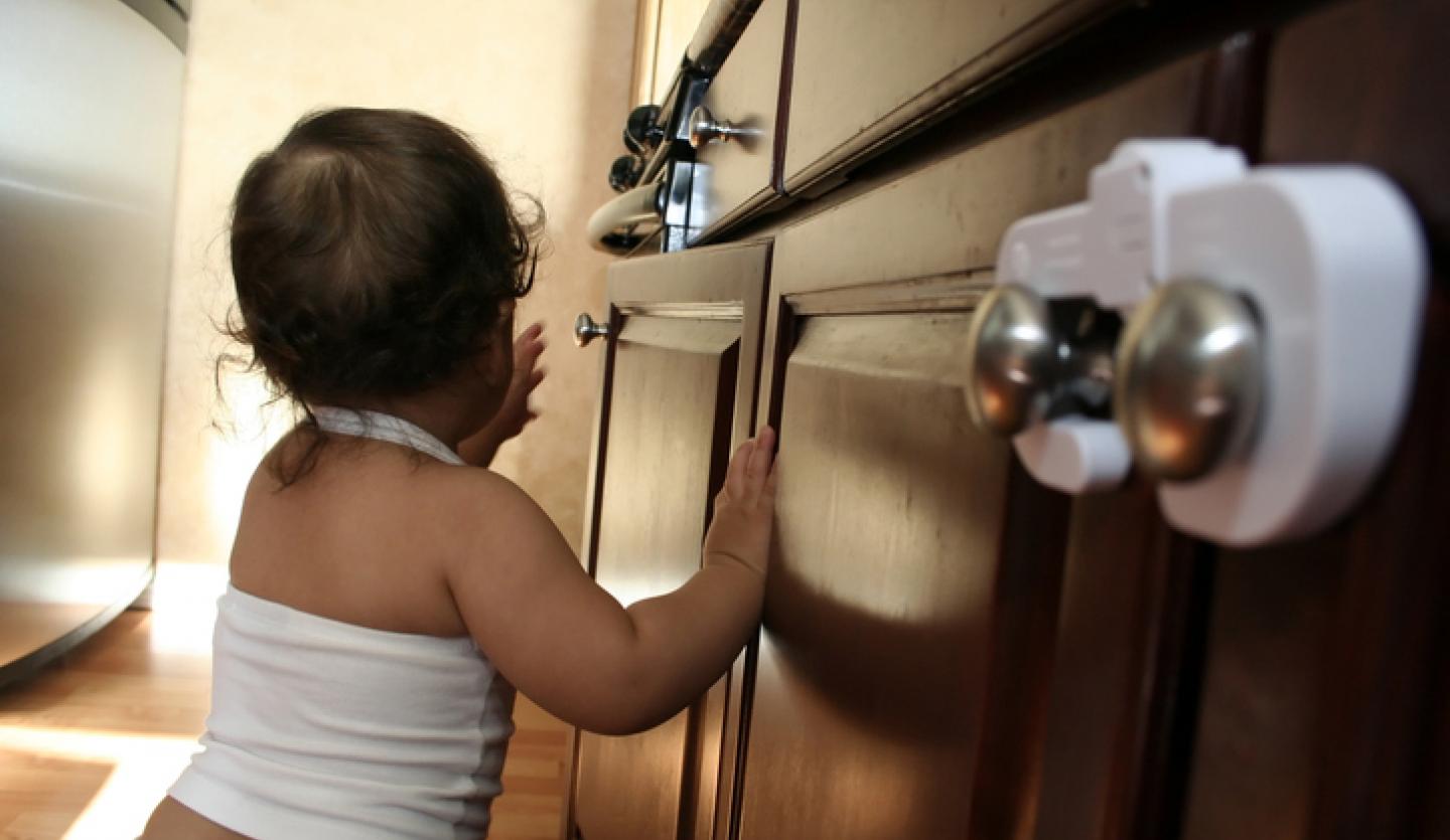 child exploring kitchen cabinet