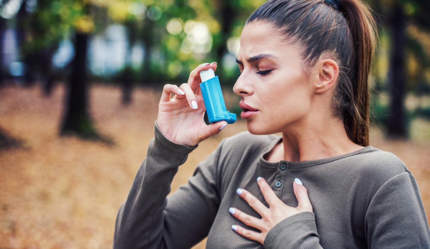 person using asthma inhaler