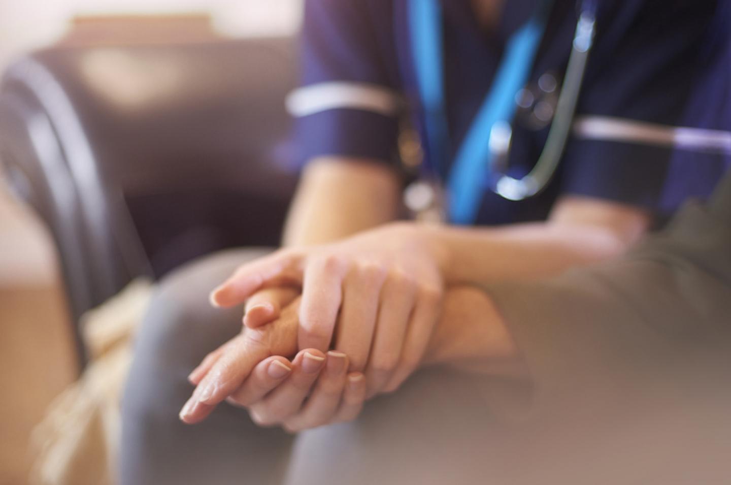 nurse holding patients hand