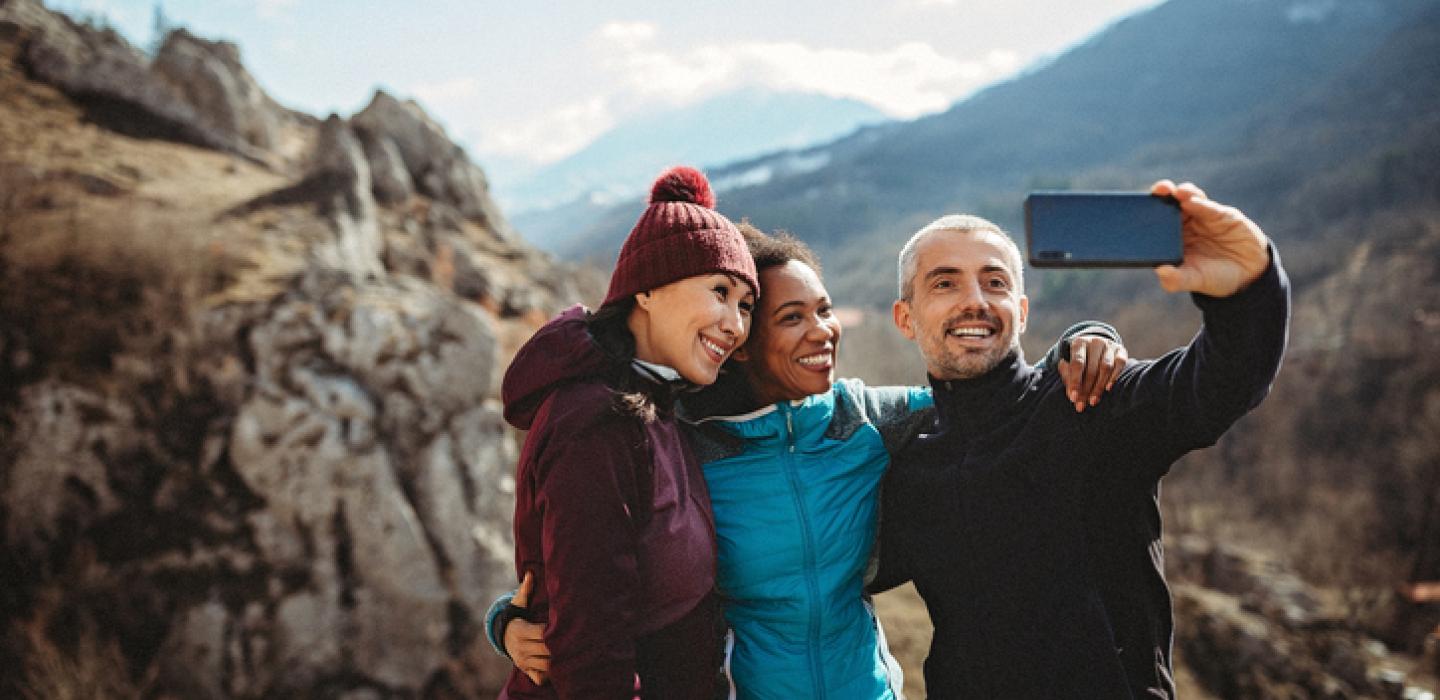 group of friends taking selfie on mountain