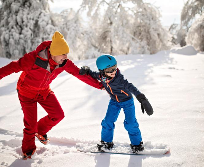 man and child snowboarding
