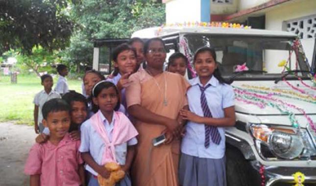 Students at the school operated by the Ursuline Sisters in Kartic, India, in front of the vehicle purchased with a grant from the Catholic Health Caregivers Fund.