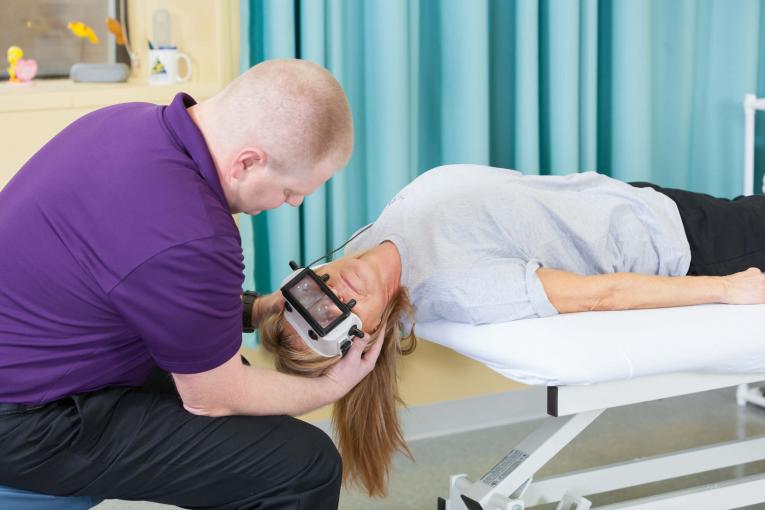 A St. Charles Hospital rehabilitation therapist uses Frenzel goggles for vestibular therapy.