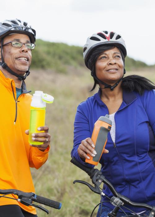 man and woman outside with bikes and water bottles
